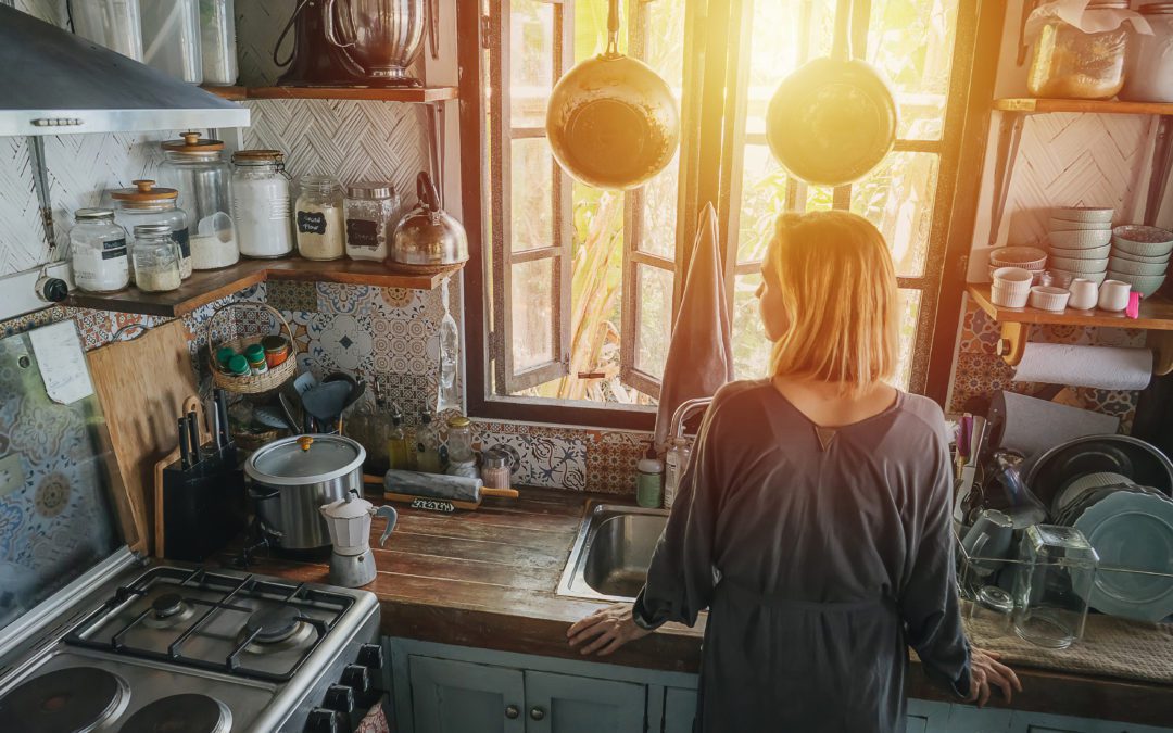 woman in small, cluttered kitchen