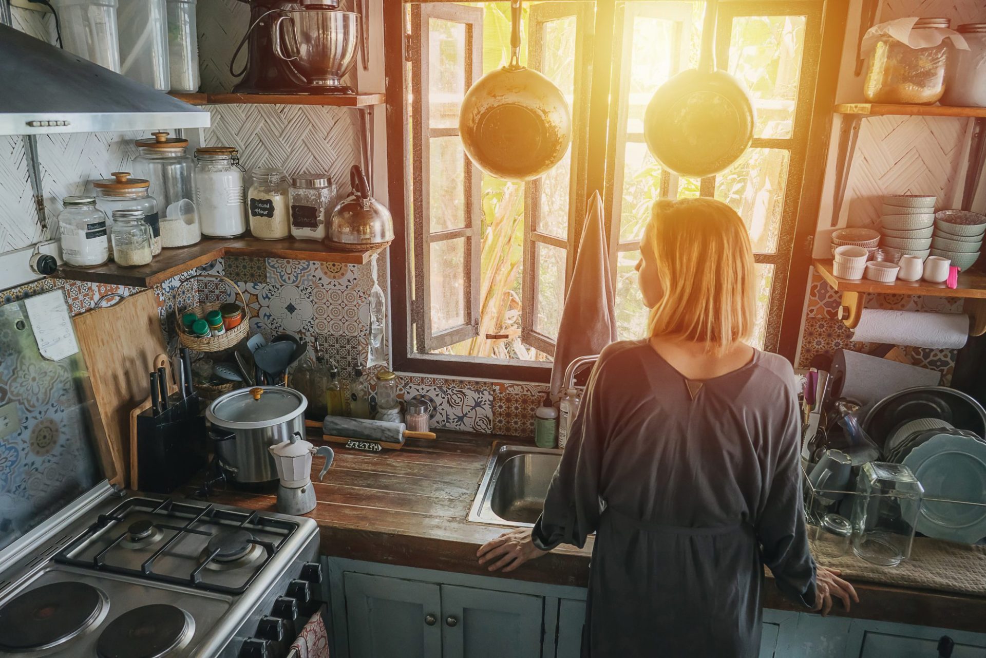 woman in small, cluttered kitchen