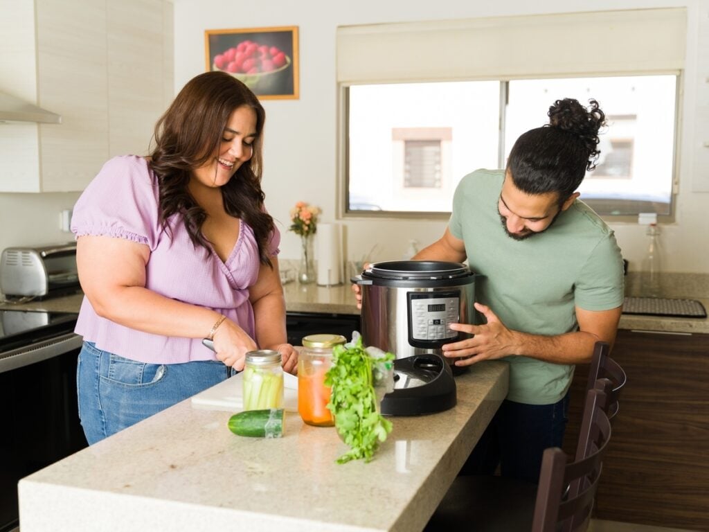Couple cooking in the kitchen with a slower cooker.